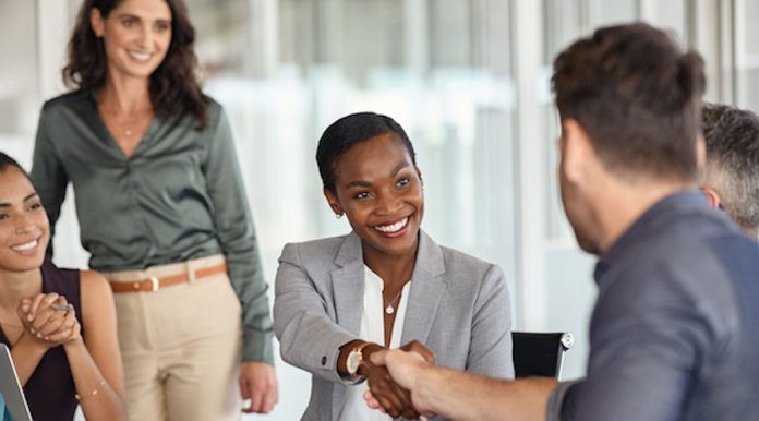 Mature black businesswoman shaking hands with new business partner